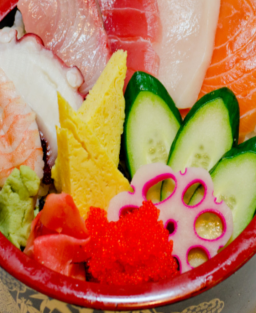 Donburi (丼物) Chirashi Don (ちらし丼)  Bol de riz japonais garni de poisson cru, légumes et garnitures, une spécialité colorée.