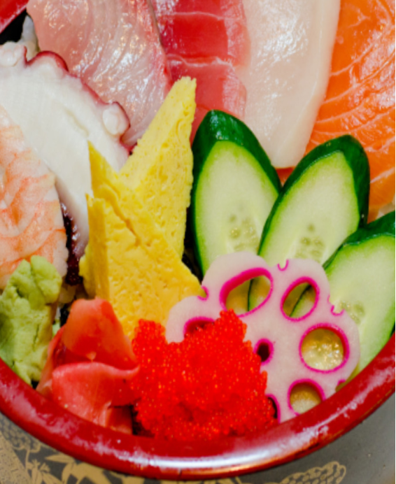 Donburi (丼物) Chirashi Don (ちらし丼)  Bol de riz japonais garni de poisson cru, légumes et garnitures, une spécialité colorée.