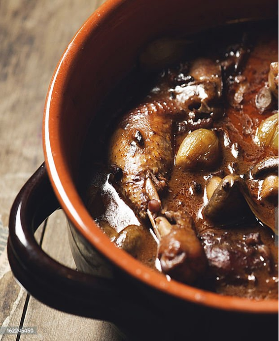 Recette traditionnelle du Coq au Vin, excellence culinaire de Bourgogne mijotée au vin rouge et bouquet garni